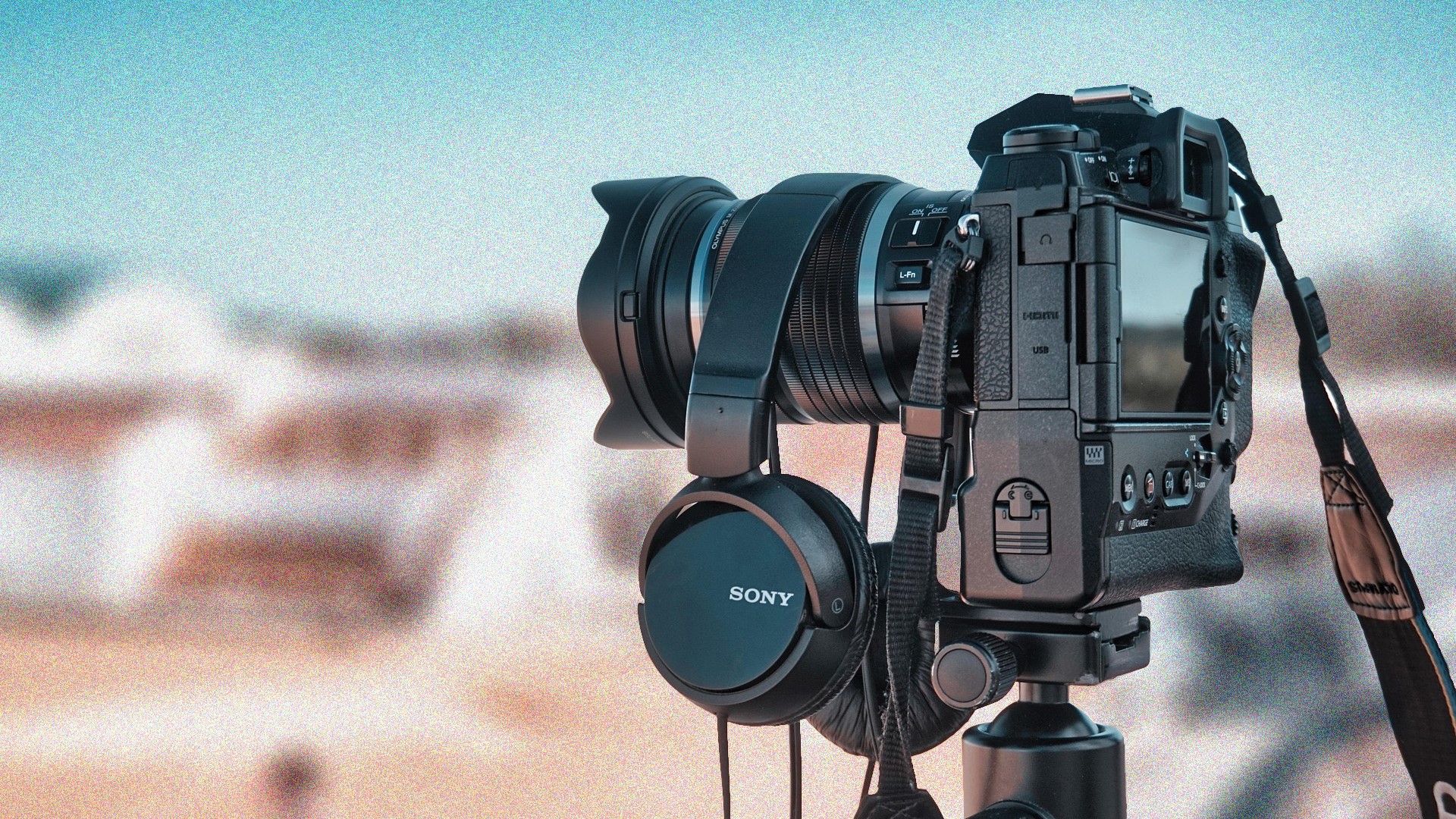 Kamera mit Portraitobjektiv vor unscharfem beigem Hintergrund – Symbol für die LinkedIn-Fotoaktion